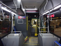 The interior of bus #7900 at CTA's South Shops Maintenance Facility on February  6, 2014. At the front of the bus, the most notable change from past CTA bus models is the more substantial protective barrier for bus operators. Elsewhere, the twin front seats behind the driver on CTA's previous generation Nova LFS buses have been replaced with a single, aisle-facing seat. Various computer equipment is located in a compartment suspended above this seat, necessitating a sign warning of the limited 175cm vertical clearance. Note the visible wiring for CTA's Ventra card reader, which was not yet installed at the time of this photograph.